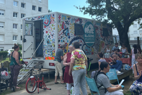 Photo prise devant une résidence Silène lors d'un événement Silène. Au premier plan, on voit l'unité mobile le MarSOINS, avec des bénévoles et des locataires.