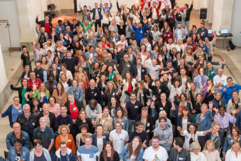 Photo des collaborateurs de Silène prise lors de la journée du personnel en juin 2024 dans la galerie des franciscains. Photo prise de haut, les collaborateurs ont le sourire et lève les bras pour certains.