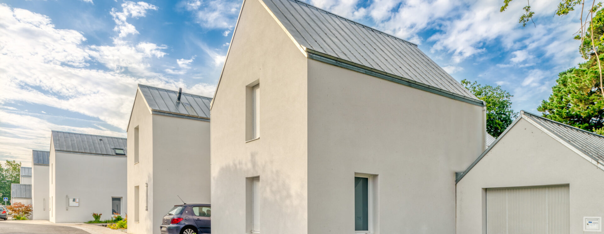 Photographie de maisons avec un grand ciel bleu.