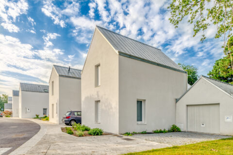 Photographie de maisons avec un grand ciel bleu.
