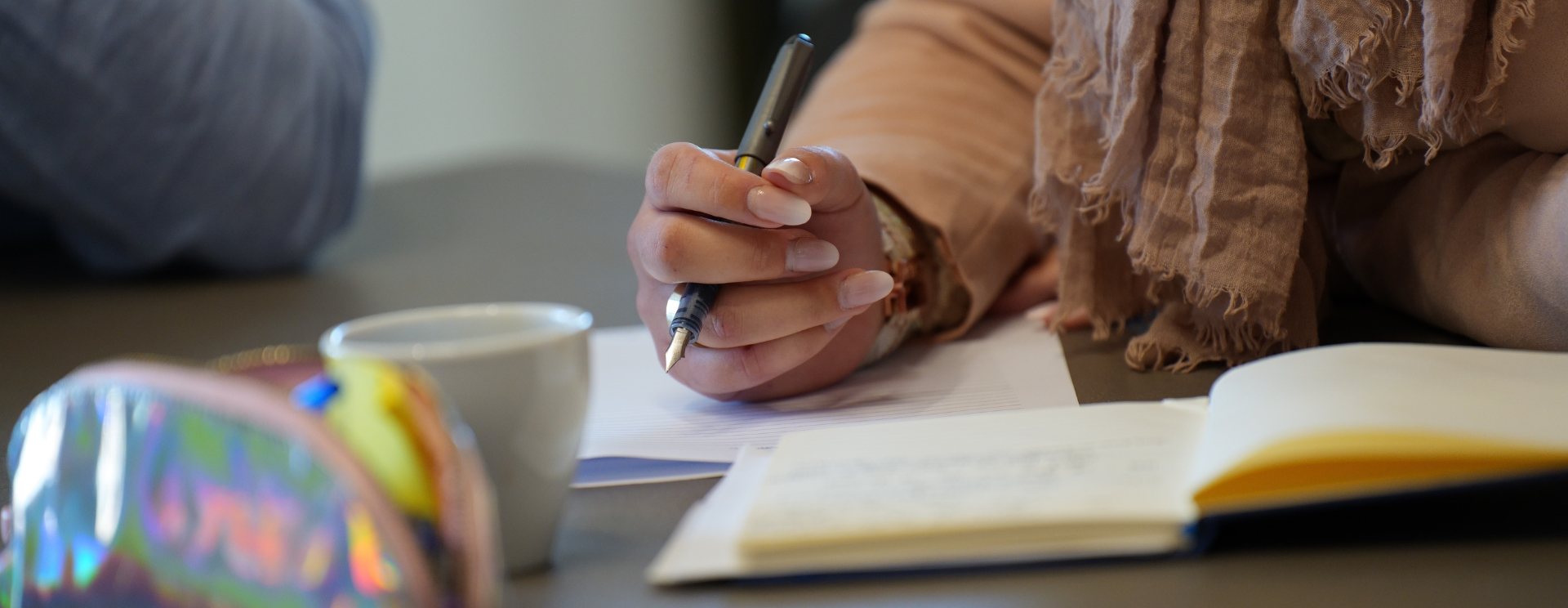 Photo en gros plan de la main d'une femme qui est en train de prendre des notes.