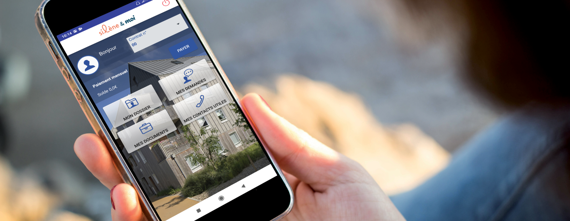 Photo en gros plan d'une main tenant un téléphone avec l'application Silène&moi ouverte.